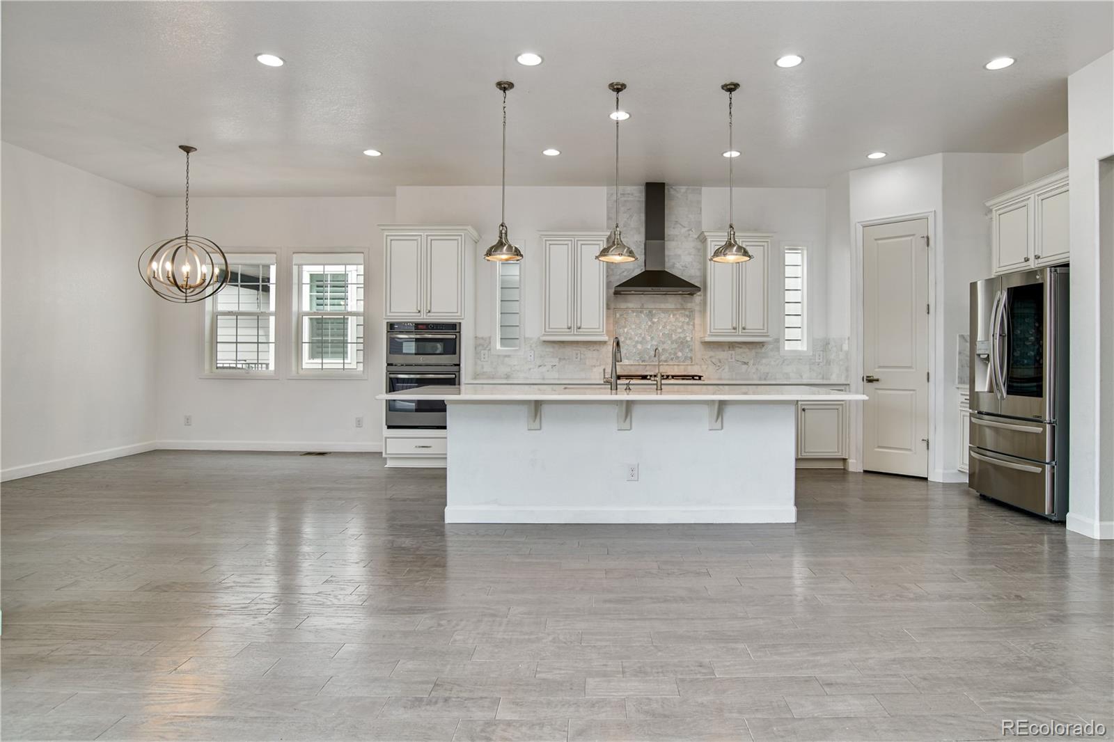 a large kitchen with stainless steel appliances kitchen island a large counter top and a stove top oven