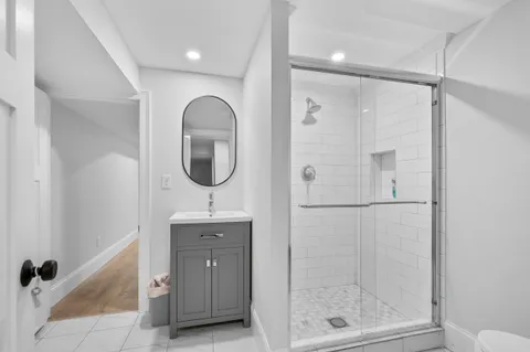 a bathroom with a mirror a shower and a sink
