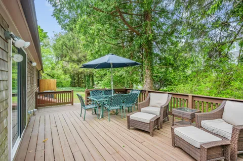 an outdoor sitting area with furniture and wooden deck