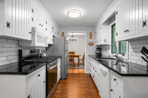 a kitchen with stainless steel appliances granite countertop a stove a sink and a refrigerator