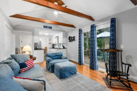a living room with furniture wooden floor and a large window