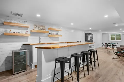 a kitchen with stainless steel appliances granite countertop table chairs sink and cabinets