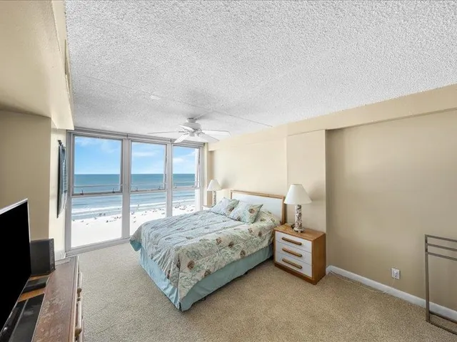 a bedroom with a bed and large windows