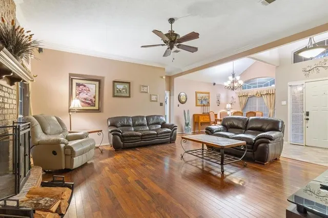 a living room with furniture a ceiling fan and a flat screen tv