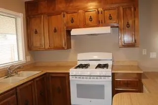 a kitchen with a refrigerator and a stove top oven
