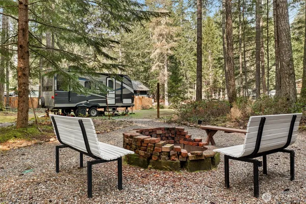 a backyard of a house with barbeque oven table and chairs