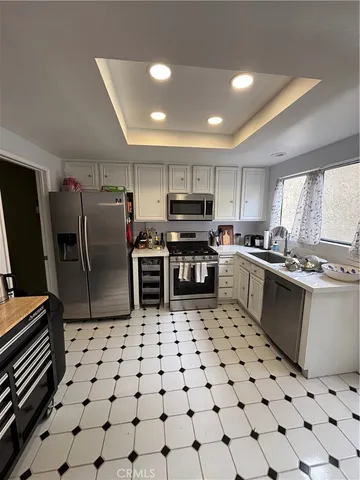 a kitchen with granite countertop a sink a counter top space cabinets and stainless steel appliances
