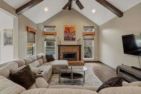 a living room with furniture a flat screen tv and a fireplace