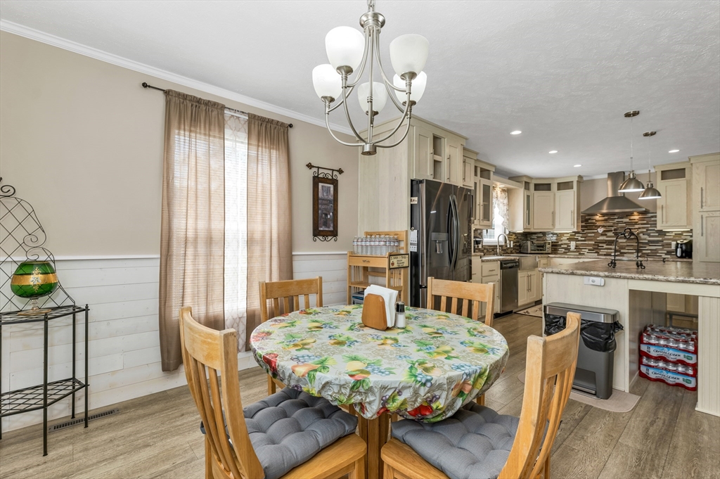 10 Ashleigh Lane, Unit 10 Rochester, NH 03867 - Photo 25 of 42 a kitchen with kitchen island a dining table chairs stainless steel appliances and cabinets