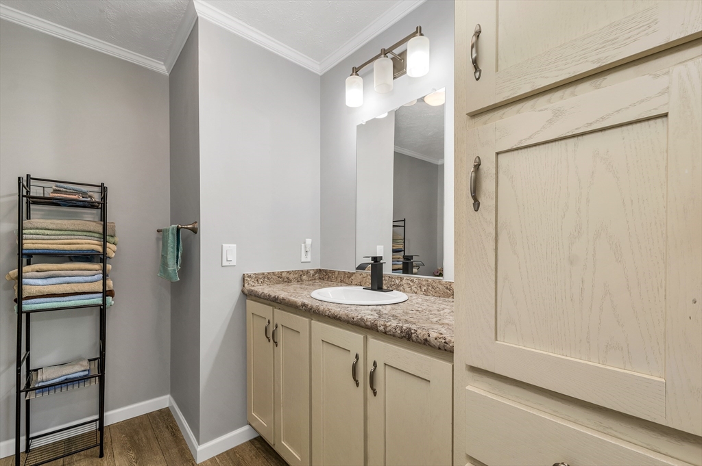 10 Ashleigh Lane, Unit 10 Rochester, NH 03867 - Photo 38 of 42 a bathroom with a granite countertop sink and a mirror