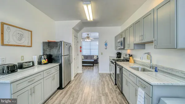 a kitchen with a sink a refrigerator and cabinets
