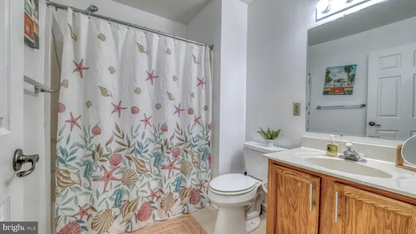 a bathroom with a granite countertop sink and a toilet