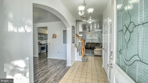 a view of a hallway with wooden floor and chandelier