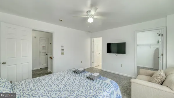 a bedroom with a bed a window and a television