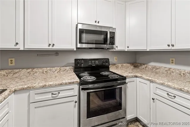 a view of a kitchen with a refrigerator and cabinets