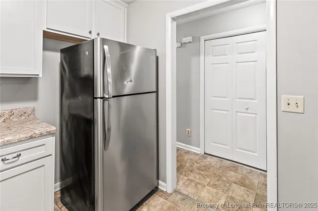 a view of an empty room with wooden floor fireplace and a window