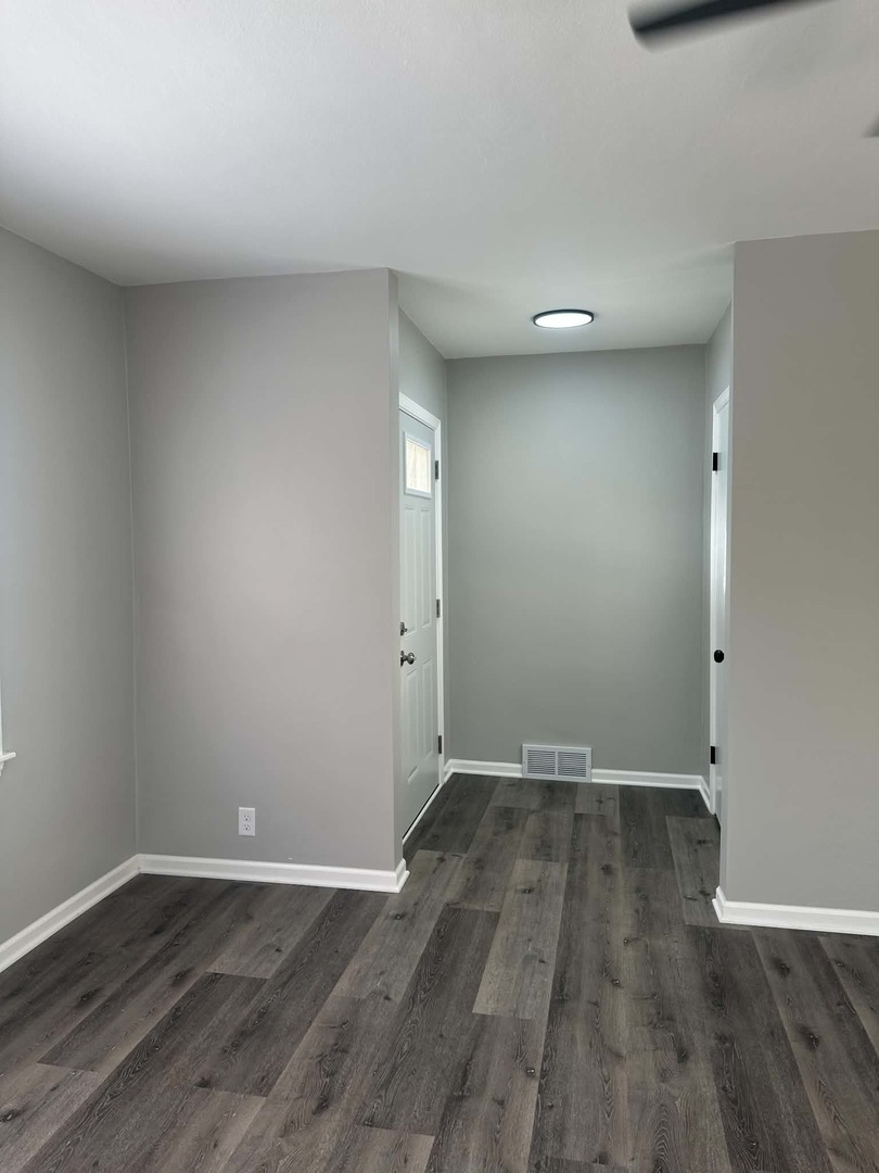 513 Cookane Avenue Elgin, IL 60120 - Photo 8 of 26 an empty room with wooden floor and natural light