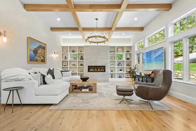 a living room with fireplace furniture and a large window