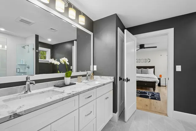 a en suite bathroom with a double vanity sink and a mirror