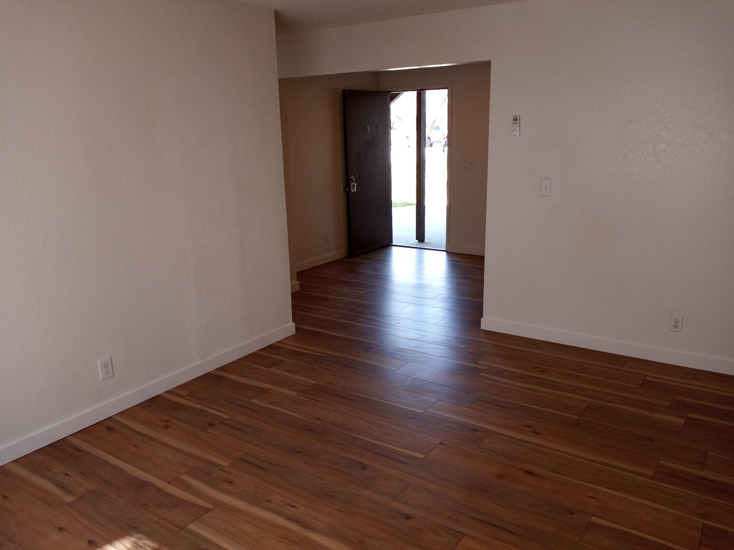 a view of a room with wooden floor and window