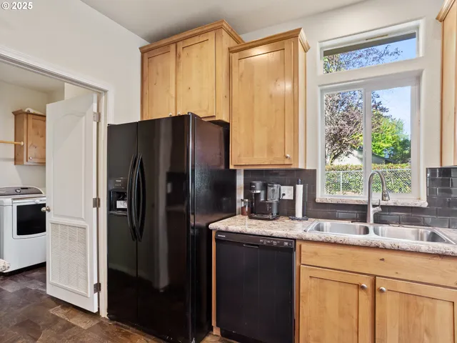 a kitchen with stainless steel appliances granite countertop a refrigerator and a sink