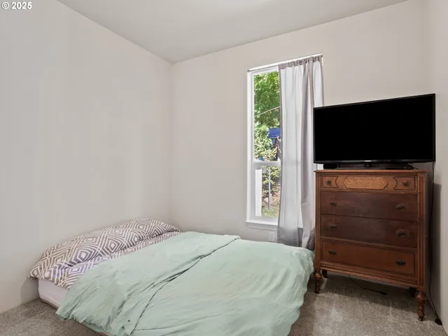 a bedroom with a bed and a flat screen tv