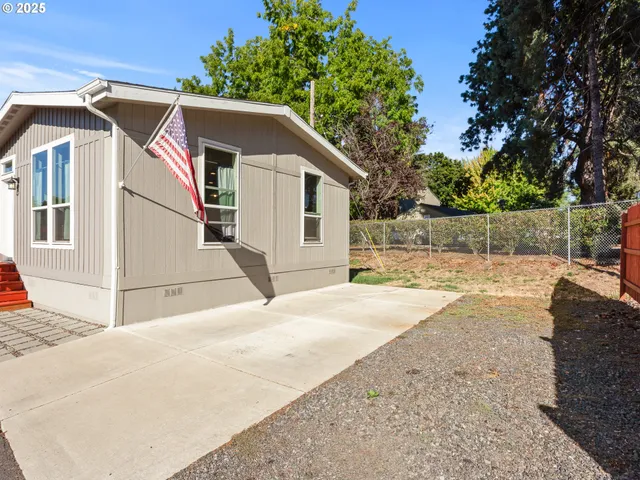 a white house that has tree in front of it