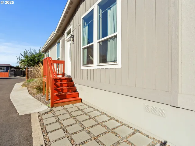 a balcony with lots of white furniture and front view of a house