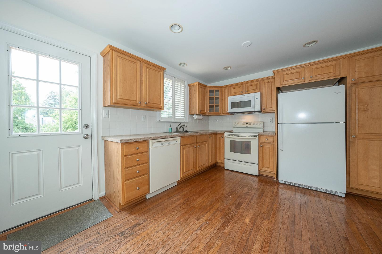 231 Plant Avenue Wayne, PA 19087 - Photo 7 of 35 a kitchen with a refrigerator a stove top oven and a window