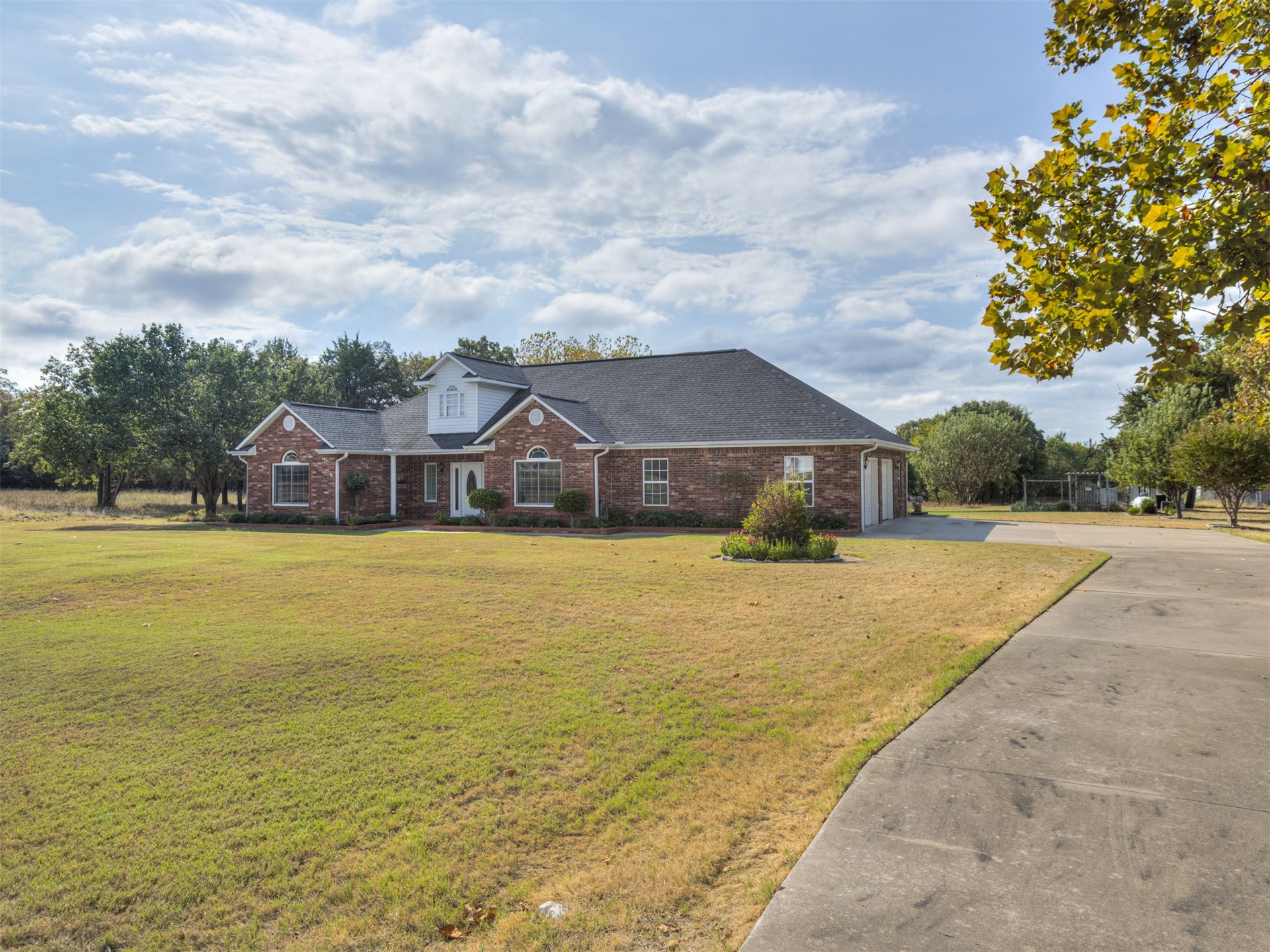 119 Mainsail Road Stigler, OK 74462 - Photo 52 of 52 Brick exterior with white trim, a gabled dormer, and an attached two-car garage