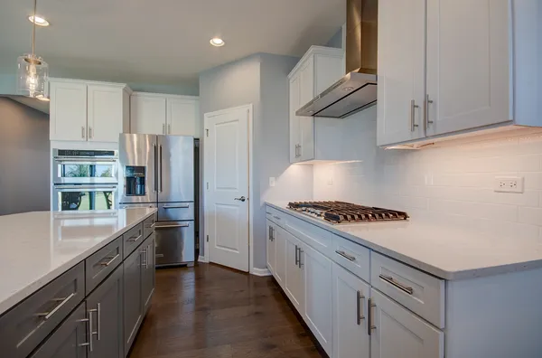 a kitchen with stainless steel appliances granite countertop a refrigerator a stove and a sink