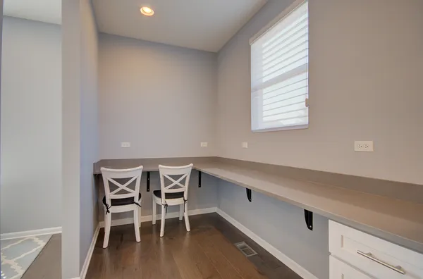 a view of a workspace with furniture and wooden floor