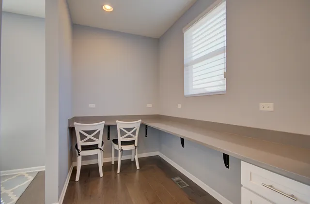 a view of a workspace with furniture and wooden floor