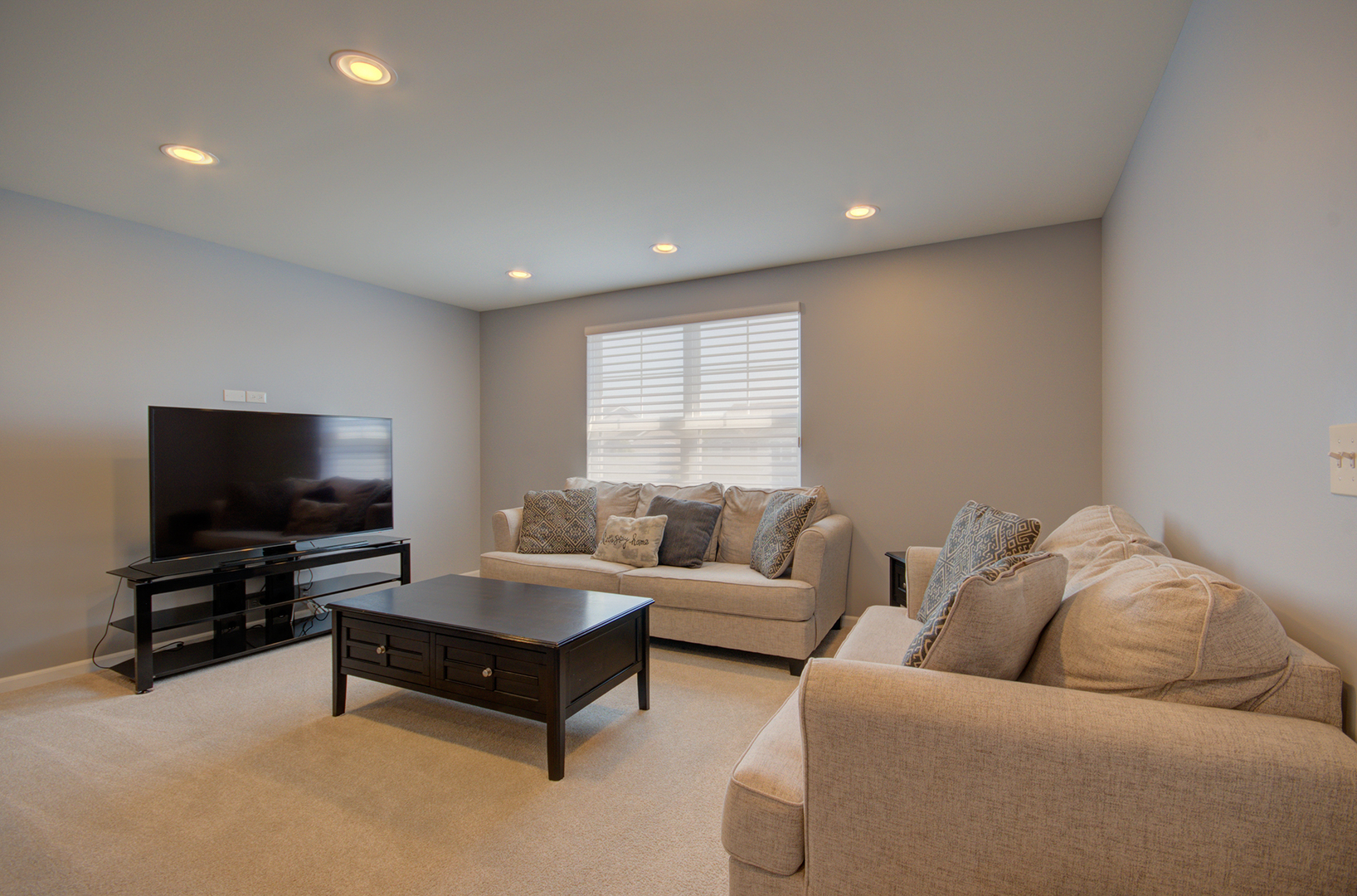 15728 Brook Shore Drive Plainfield, IL 60544 - Photo 18 of 36 a living room with furniture and a flat screen tv