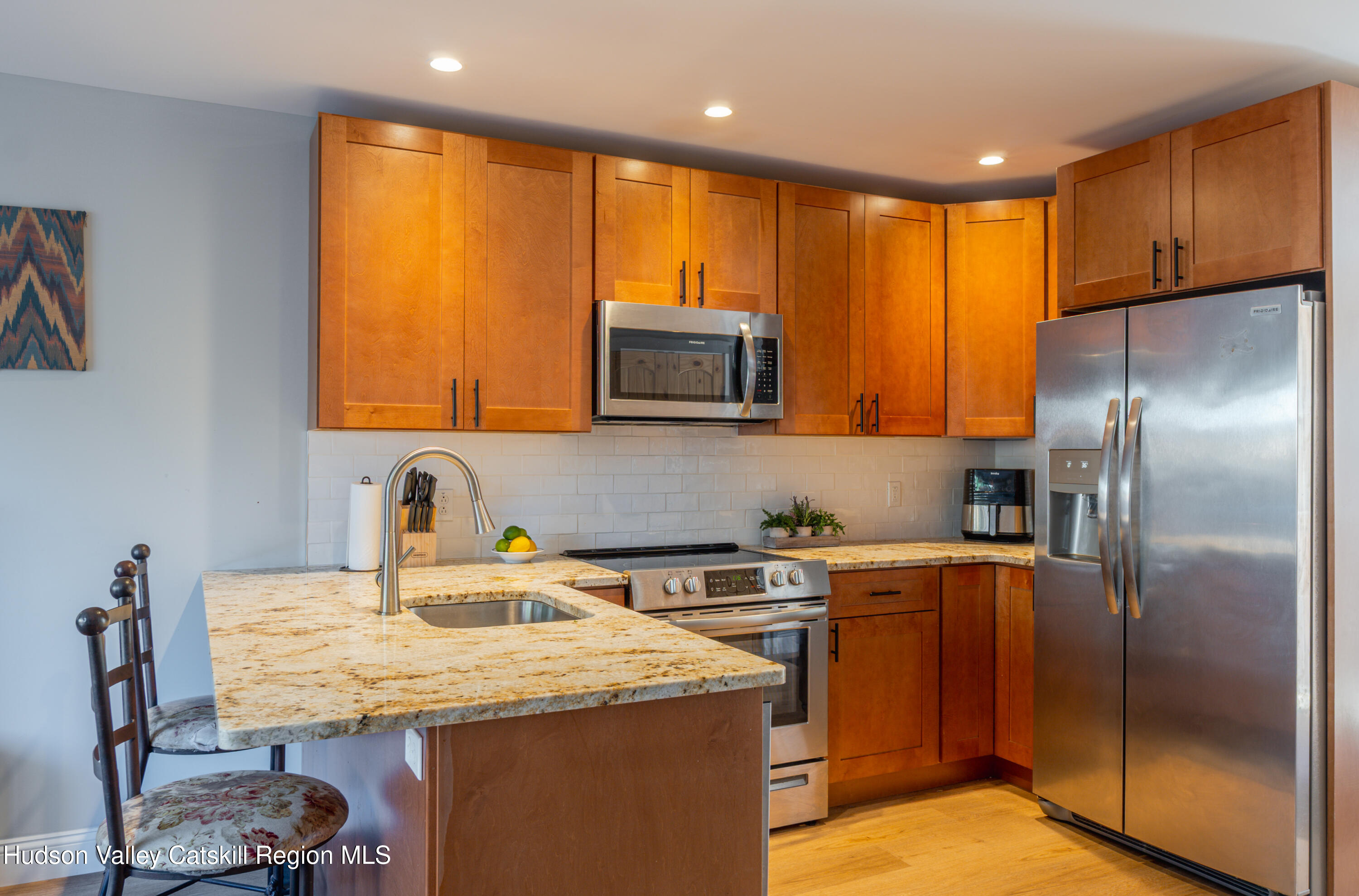 71 County Road 65, Unit 4 Windham, NY 12439 - Photo 6 of 33 a kitchen with stainless steel appliances granite countertop a sink a microwave a refrigerator and wooden cabinets