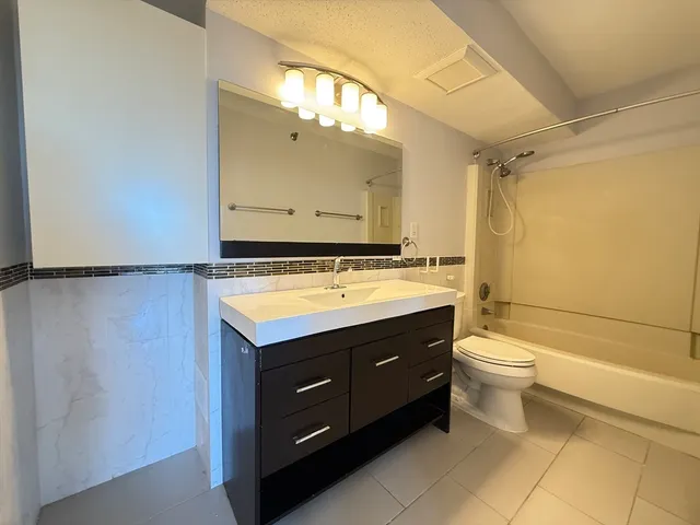 a bathroom with a sink vanity mirror and toilet