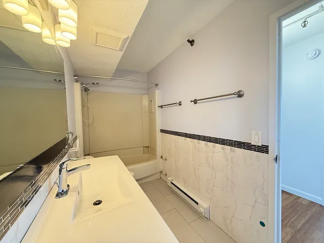 a bathroom with a tub a window and a shower