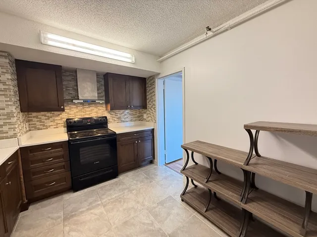 a kitchen with granite countertop a sink cabinets and stainless steel appliances