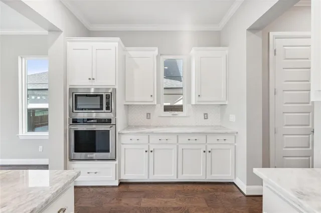 a kitchen with stainless steel appliances white cabinets and a refrigerator