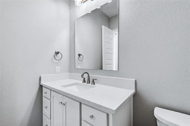 a bathroom with a sink toilet and mirror