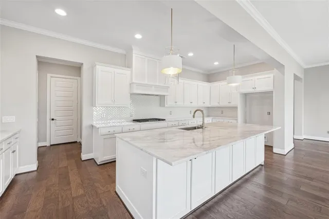 a kitchen with white cabinets appliances and sink