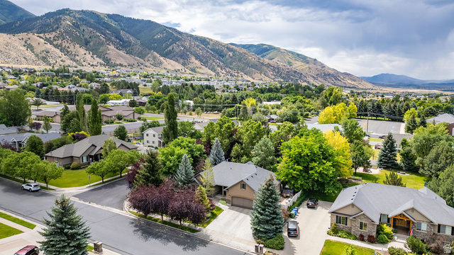288 525 South Providence, UT 84332 - Photo 67 of 71 Aerial perspective highlighting a residential neighborhood with established homes, mature trees, and mountainous terrain in the background
