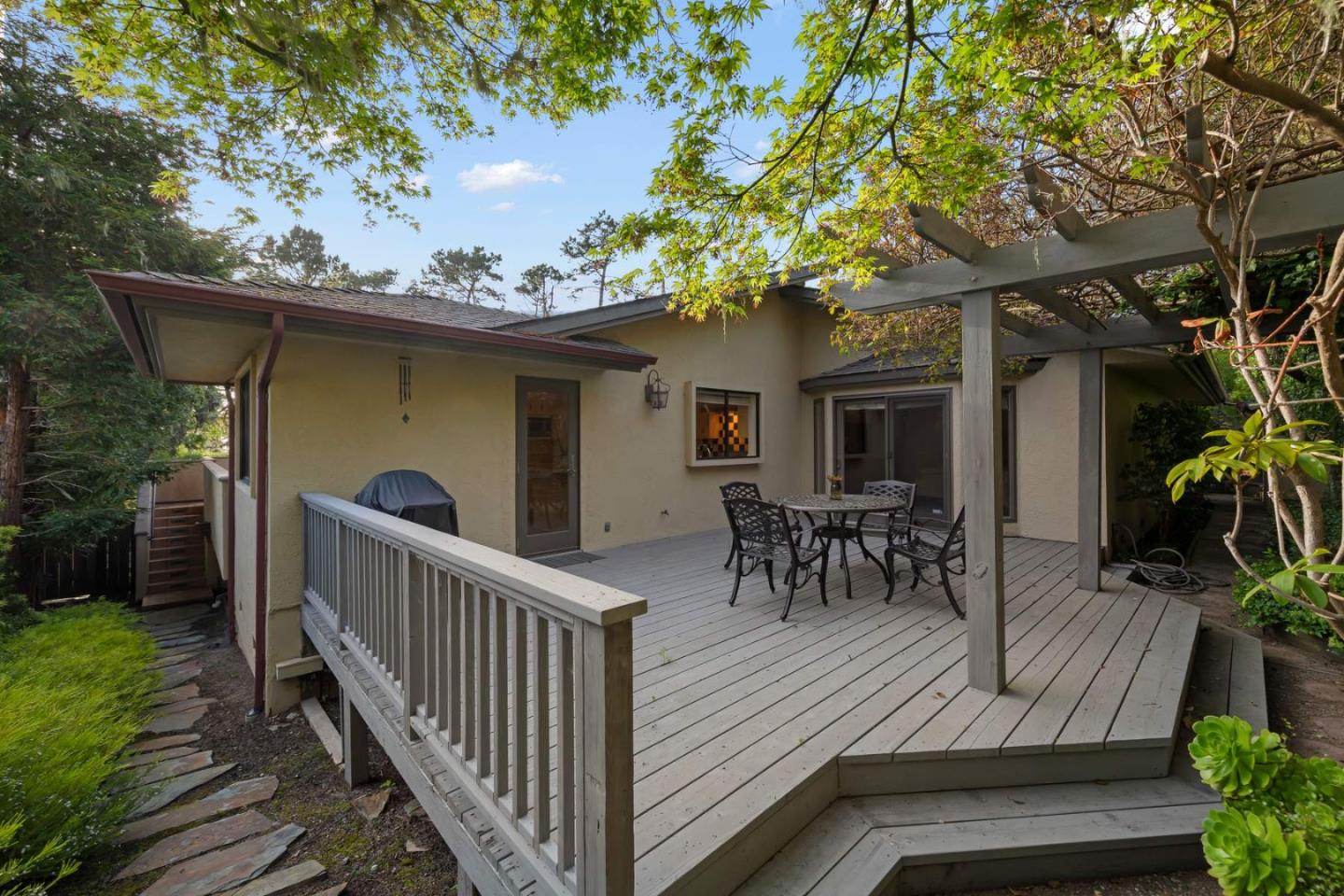 3041 Strawberry Hill Road Pebble Beach, CA 93953 - Photo 29 of 31 a view of a patio with table and chairs and potted plants with wooden floor and fence