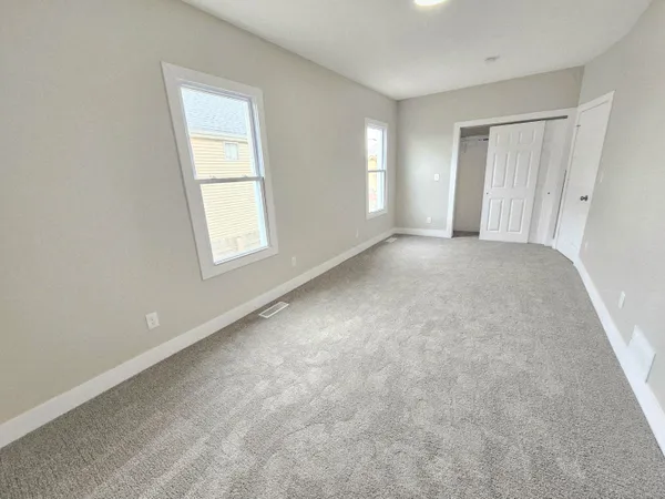 an empty room with windows and closet