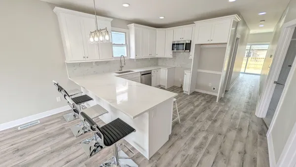 a kitchen with kitchen island white cabinets and stainless steel appliances