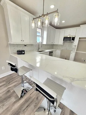 a large kitchen with kitchen island a stove a table and chairs in it