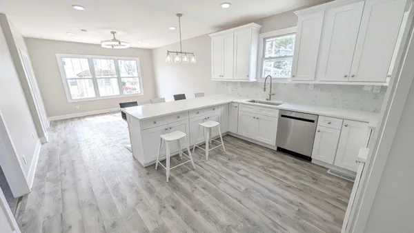 a kitchen with granite countertop white cabinets white appliances sink and window