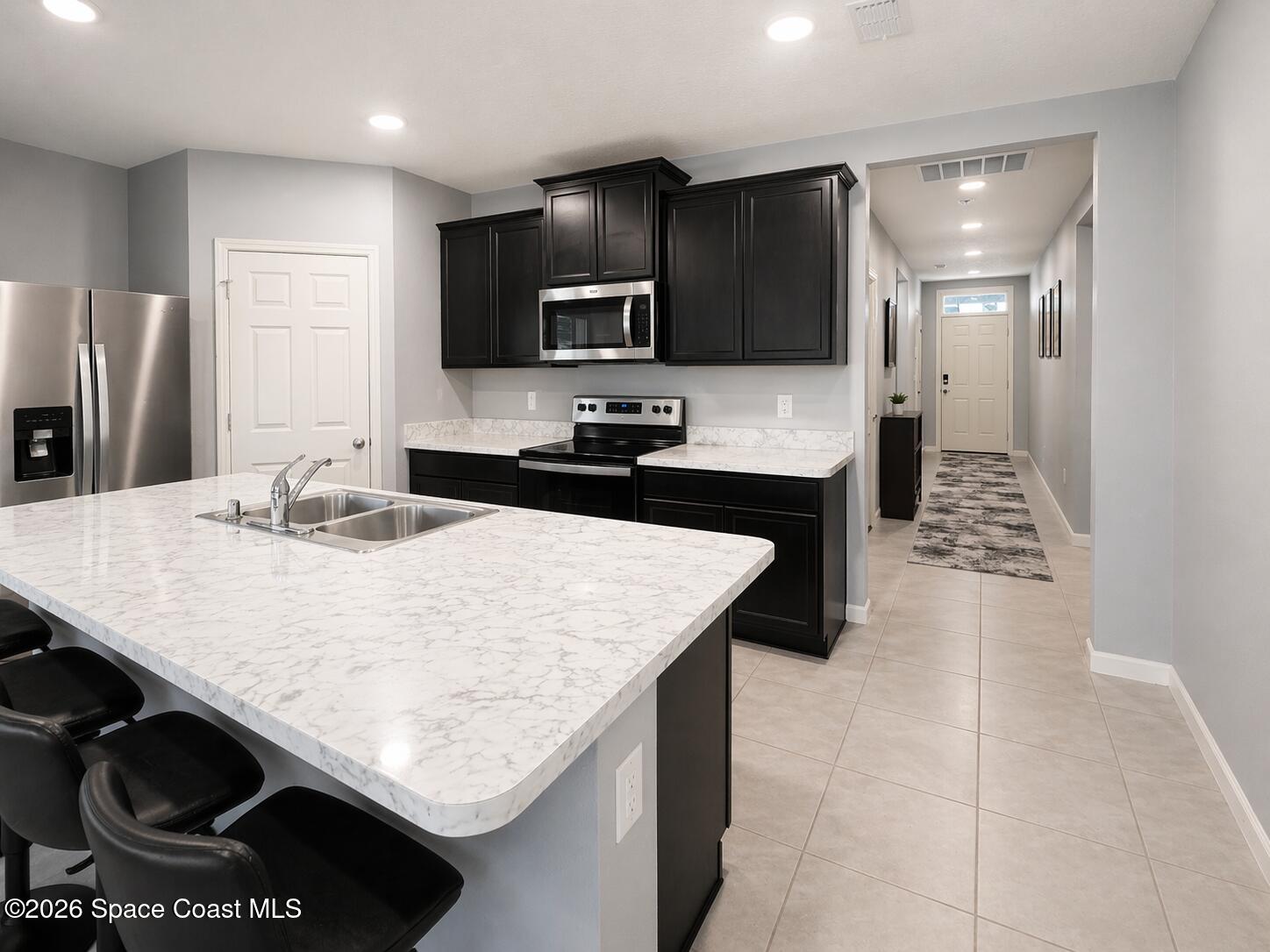 4731 Talbot Boulevard Cocoa, FL 32926 - Photo 9 of 18 a kitchen with stainless steel appliances a sink stove and refrigerator