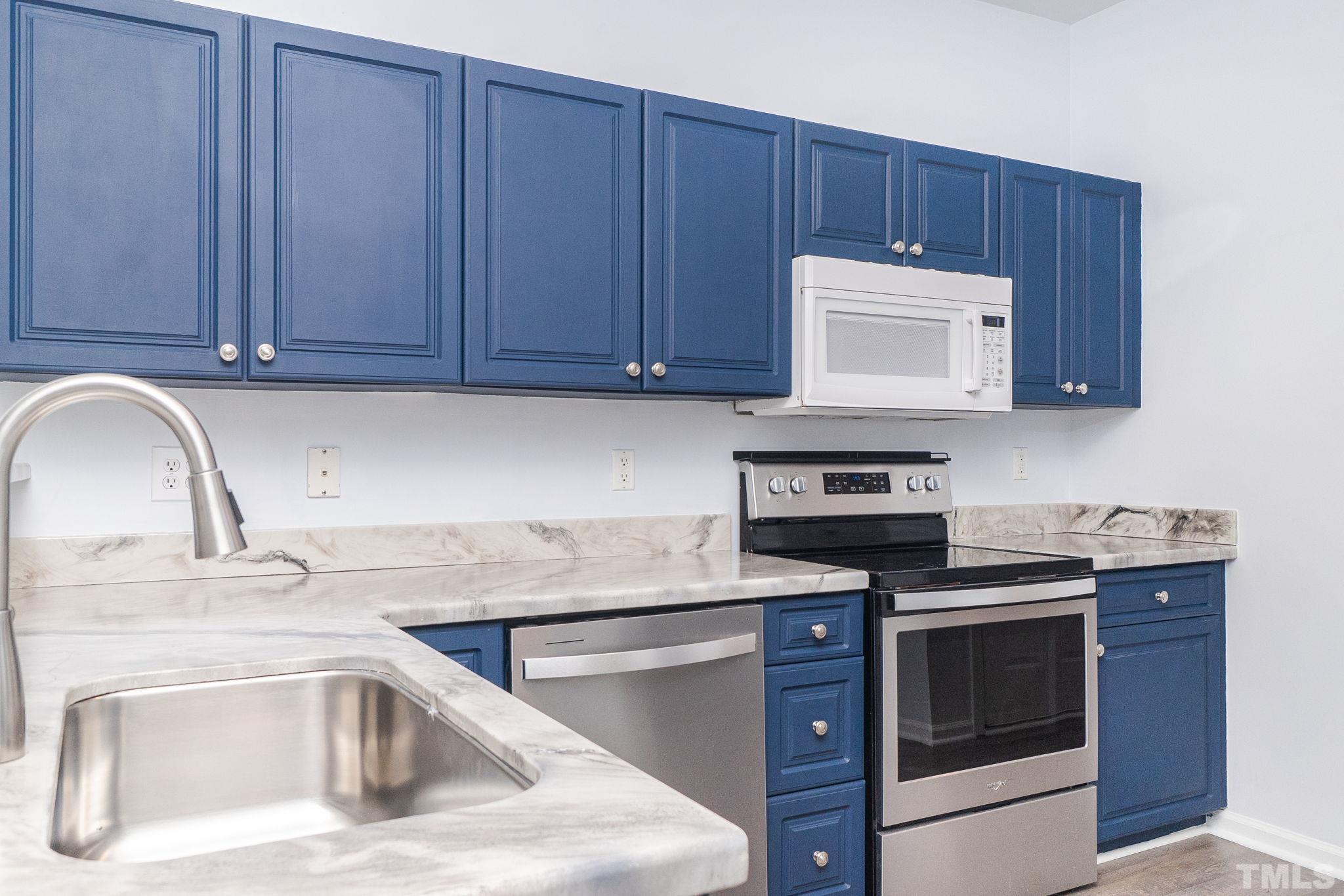 6920 Missionary Ridge Drive Raleigh, NC 27610 - Photo 13 of 34 a kitchen with granite countertop wood cabinets and white appliances