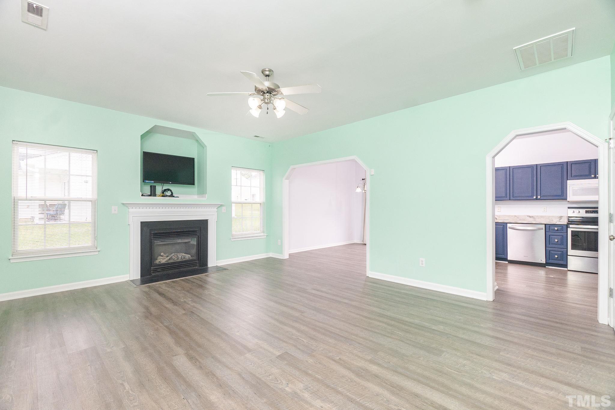 6920 Missionary Ridge Drive Raleigh, NC 27610 - Photo 7 of 34 a view of a livingroom with a fireplace a ceiling fan and wooden floor
